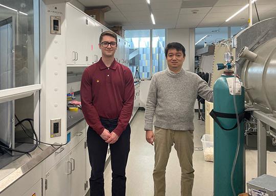 two men, a professor and a student, standing in an engineering lab